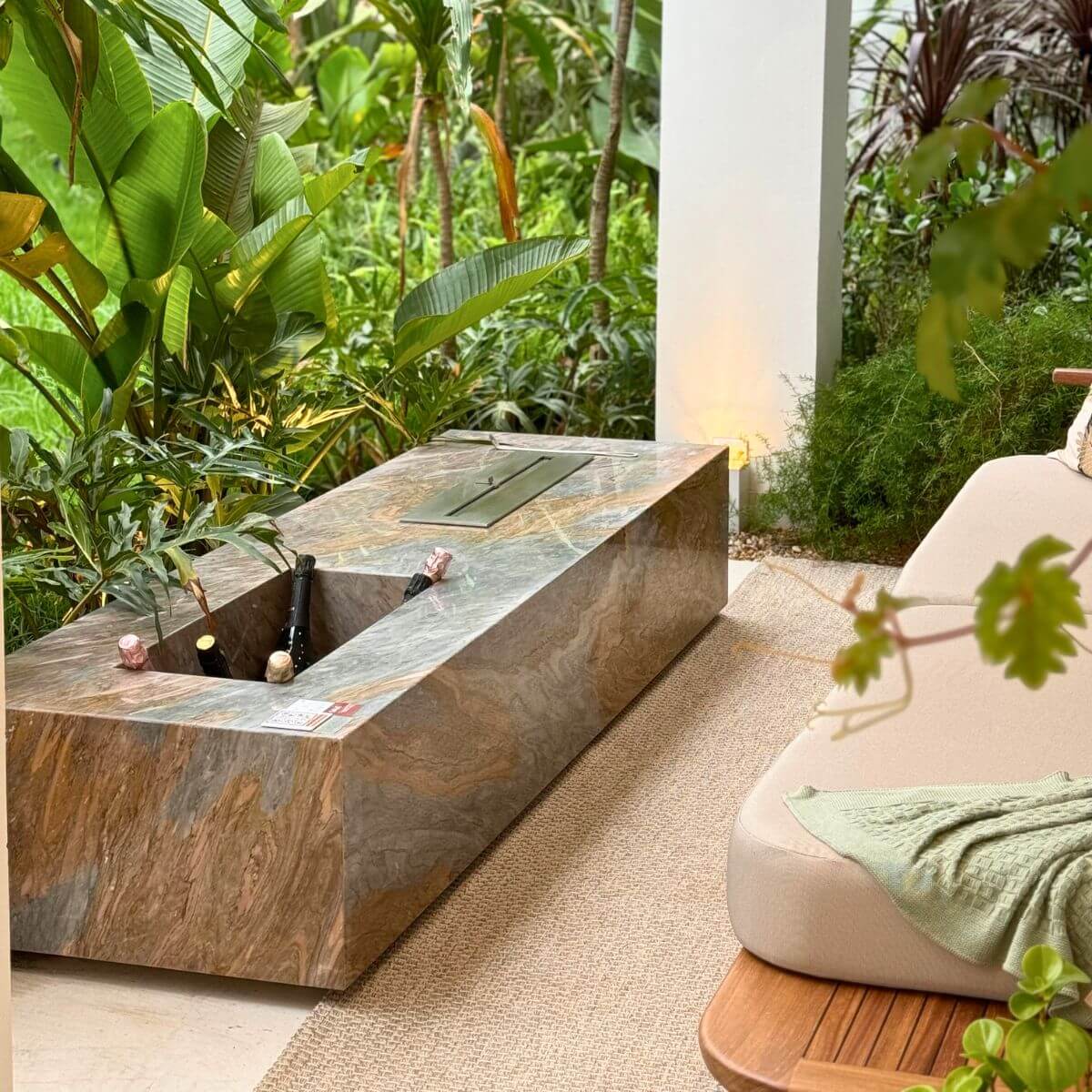 Sala de estar com lareira ecológica Somer instalada em nicho de pedra.