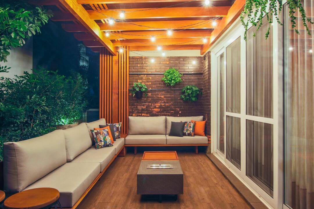 Sala de estar com lareira ecológica Somer instalada em nicho de pedra.