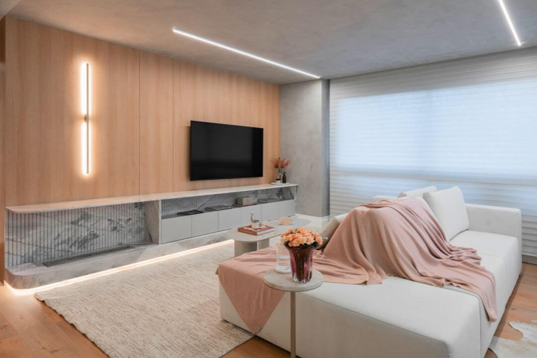 Sala de estar com lareira ecológica Somer instalada em nicho de pedra.